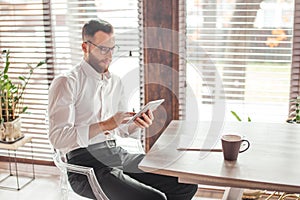 Serious applicant sitting in boardroom, preparing for interview with employer.