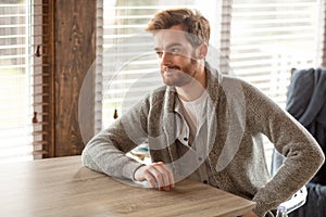 Serious applicant sitting in boardroom, preparing for interview with employer.