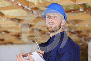 Serious architect or engineer taking notes on clipboard