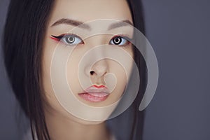 Serious asian beauty woman with creative make-up. Close-up portrait.