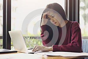 Serious asian business woman thinking of problem to working, tried to new project using laptop computer at office