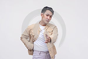 A serious asian man coming to an agreement, offering a handshake. Isolated on a white background