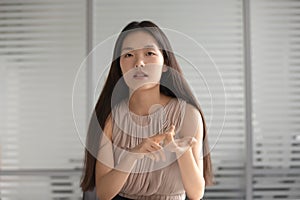 Serious asian professional businesswoman look talk to camera in office