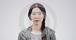 Serious asian woman, face and blank stare standing isolated against a studio background. Portrait of attractive Japanese