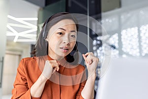 Serious Asian woman listening online conversation close up, businesswoman with headset phone, online customer support