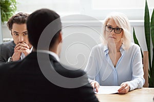 Serious attentive senior hr listening to candidate at job interv photo