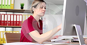 Serious attentively business woman working with documents and computer in fose