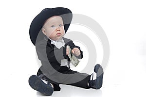 Serious baby boy in hat with us dollar