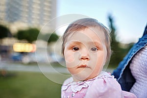 Serious baby thinking on nature green background and looking with interest.