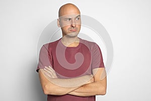 Serious bald man looking aside with suspicion