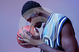 Serious basketball player with ball in studio