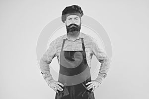 Serious bearded chef. brutal male cook in hat and apron. professional man cooking. restaurant cuisine and culinary
