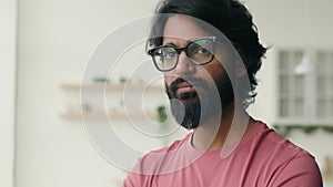 Serious bearded man muslim guy looking at camera at home. Portrait ethnic Indian businessman in eyeglasses Arabian