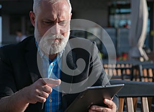 Serious bearded man with a tablet stock photo