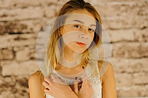 The serious beautiful teenage girl with blond hair. The close-up portrait.