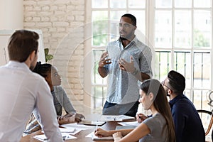 Serious black manager talk to diverse staff people at meeting