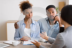 Serious Black Couple Listening To Financial Advisor During Investment Consultation