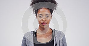 Serious black woman, blank stare and standing isolated against a studio background. Face portrait of attractive African