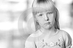 Serious blond little girl looking sadly photo