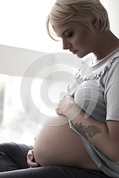 Severe pregnant woman hugging her tummy