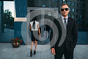 Serious bodyguard in suit and sunglasses, guarding