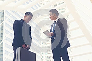 Serious boss talking to employee   about project at outside office,Business concept