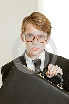 Serious boy in business suit and brief case