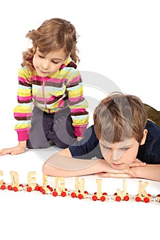 Serious boy and girl playing with wooden railway