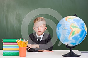 Serious boy at his desk in the classroom