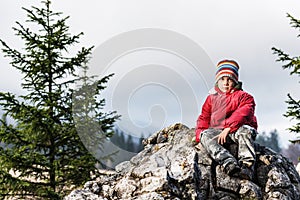 Serious boy standing on a cliff