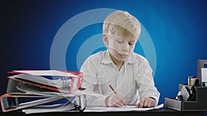 Serious boy writing writing pen on paper