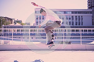 Serious brunette male person jumping on skateboard