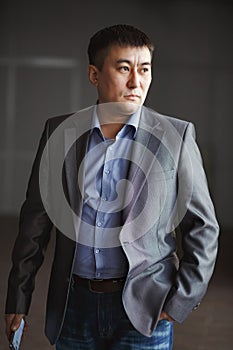 Serious brutal asian business man with phone in