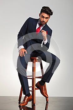 Serious business man in elegant double breasted suit sitting