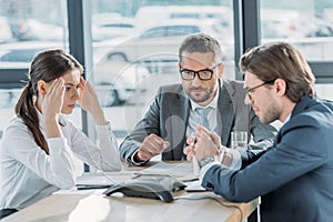 serious business people having conversation and using speakerphone