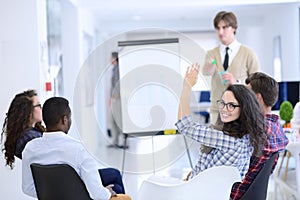 Serious business team with flip board in office discussing something