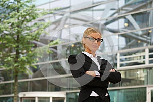 Serious business woman in glasses standing outdoors