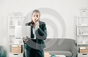 Serious business woman, office manager with phone at office desk. Businesswoman entrepreneur working in office