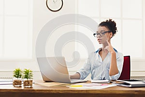 Serious business woman working on laptop at office