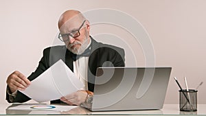 Serious Businessman with Beard and Glasses Analyzing Charts on Computer