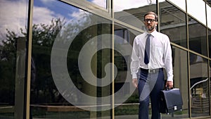 Serious businessman with briefcase going to work, purposeful and successful