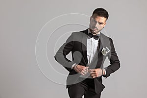 Serious businessman buttoning black tuxedo