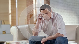 Serious businessman in casual clothes having phone conversation with partner