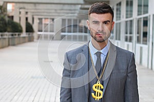 Serious businessman with dollar sign necklace
