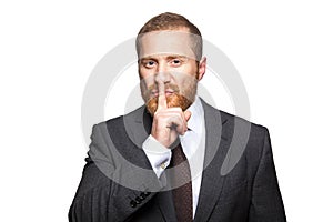 Serious businessman with finger on lips making silence gesture. Shh!!!