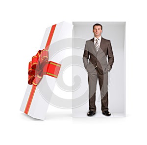 Serious businessman in gift box on white