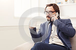 Serious businessman having phone talk