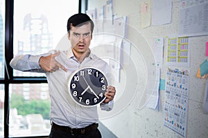 Serious businessman holding big clock in his hands, Time to work