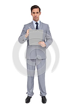 Serious businessman holding a clipboard