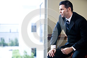 Serious businessman looking out office window